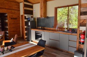 a kitchen with a table and a dining room at Rümü in Pucón