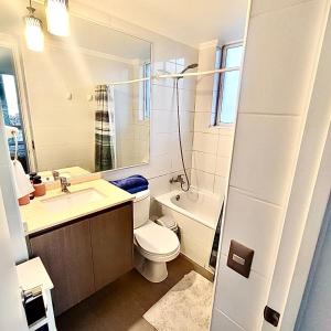 a bathroom with a toilet and a sink and a tub at Edificio Lynch- Sector Centro Depto Full Equipado 2D2B Estacionamiento in Iquique