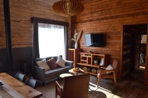a living room with a couch and a tv at Rümü in Pucón