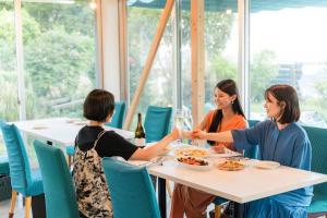 a group of women sitting at a table eating food at 白浜レジデンス 1日1組限定 ファミリー向け 炭火焼イタリアンディナー付き in Minamiboso