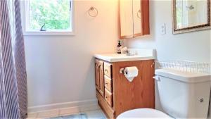 a bathroom with a toilet and a sink and a window at 505 Sandalwood Road in Wildwood Highlands Beach +23 photos