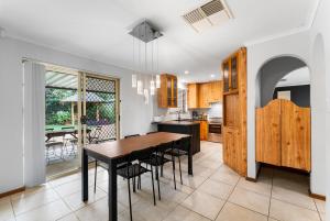 a kitchen and dining room with a table and chairs at Private 4BR Garden Haven - Spacious & Serene in Mawson Lakes