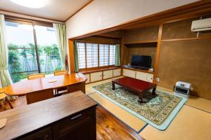 a living room with a table and a desk at 勝山恐竜博物館まで車で10分最大10名様ふとん屋の宿 悦 in Katsuyama