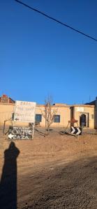 a shadow of a person taking a picture of a sign at ZAZA Guest house in Agoudal +9 photos