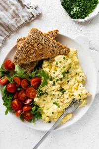 a plate of food with eggs and toast and tomatoes at Nisa hostel in Pakse +21 photos
