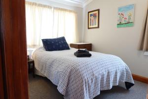 a bedroom with a bed with a white blanket and a window at La Casa in Napier +23 photos