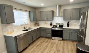 a kitchen with gray cabinets and white counter tops at Modern Luxury Haven in Colorado Springs