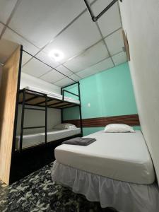 two beds in a room with two bunk beds at Hostal Villa Marta in Santa Ana