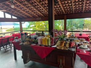 a buffet of food on a table in a restaurant at Pousada Sol e Cia Tur in Caraguatatuba
