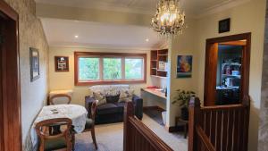 a living room with a chandelier and a chair and a table at La Casa in Napier