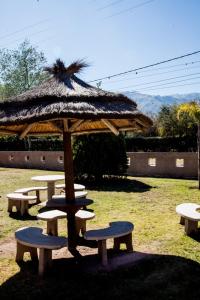 a group of picnic tables with a large umbrella at Posada Merlo in Merlo