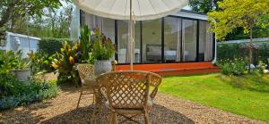a table and chairs with an umbrella in a garden at Ari & Alki Garden in Ban Nong Nam Khan