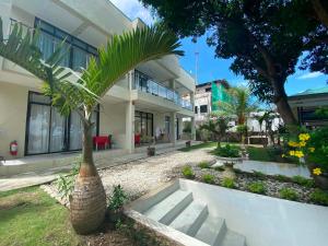 a house with a palm tree in front of it at Bentrina Diving Resort in Mabini