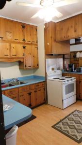a kitchen with wooden cabinets and a white stove top oven at Historic Matewan House Lodging in Matewan