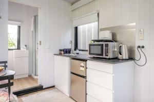 a kitchen with a microwave and a counter top with a microwave at Deloraine Tiny Retreat by Tiny Away in Whangarei +32 photos