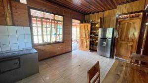 a kitchen with a refrigerator and a table in a room at CABAÑA RaNCH OXAPAMPA in Oxapampa