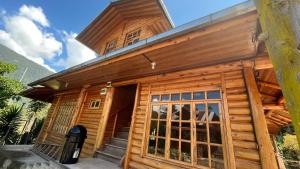 a wooden cabin with a large glass door at CABAÑA RaNCH OXAPAMPA in Oxapampa