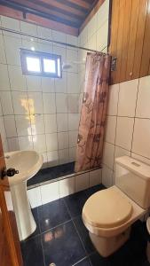a bathroom with a toilet and a sink at CABAÑA RaNCH OXAPAMPA in Oxapampa