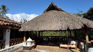 a hut with chairs and a thatched roof at Hotel Paraiso Escondido in Puerto Escondido