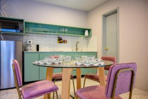 a kitchen with a table and purple chairs in a kitchen at MATAMOROS 2 · Refugio Céntrico con Piscina in Oaxaca City