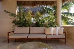 a couch sitting in a room with plants at PH POINTE · Luxury Penthouse with Pool in Brisas de Zicatela