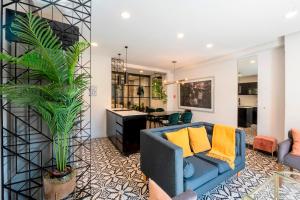 a living room with a blue couch and a plant at INDEPENDENCIA 2 · Small and Modern Apt for four in Oaxaca City