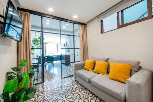 a living room with a couch with yellow pillows at INDEPENDENCIA 2 · Small and Modern Apt for four in Oaxaca City