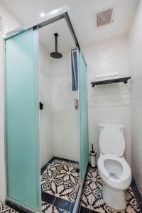 a bathroom with a toilet and a glass shower stall at INDEPENDENCIA 2 · Small and Modern Apt for four in Oaxaca City