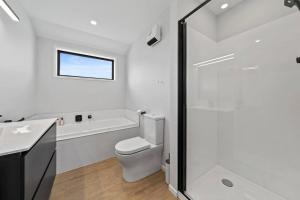 a bathroom with a toilet and a sink and a shower at The Red Door in Martinborough +25 photos