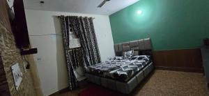 a bedroom with a bed in a room with green walls at Home stays in Jammu