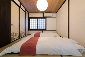 una camera da letto con un grande letto con una grande finestra di Kyotoya Tsuki no Yu Bettei a Kyoto