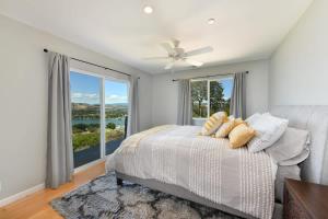 a bedroom with a bed and a large window at Vineyard Setting With 180 Panoramic Lake Views in Lower Lake