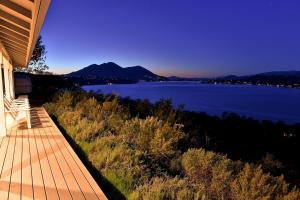 a house with a view of a lake at dusk at Vineyard Setting With 180 Panoramic Lake Views in Lower Lake