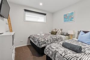 a bedroom with two beds and a window at The Red Door in Martinborough