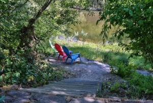 two chairs sitting on a wooden path near a lake at Heron House - Hot Tub And Wine Tastings Included in Healdsburg