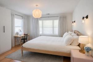 a white bedroom with a large bed and a desk at Fitch St Escape - Wine Tastings Included in Healdsburg