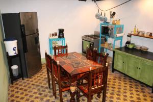 a kitchen with a table with chairs and a refrigerator at La Casa del Barrio in Quetzaltenango