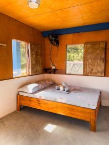 a bed in a room with two windows at L'Astrolabe - Riverside Bungalow with Sea View in Baras