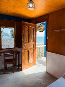 an open door to a room with a view of the ocean at L'Astrolabe - Riverside Bungalow with Sea View in Baras