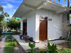 a small white house with a wooden door at Bella Nilaveli Beach in Nilaveli