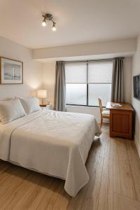 a bedroom with a bed and a desk and a window at Las Condes familiar Deluxe in Santiago