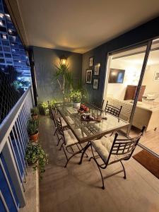 a patio with a glass table and chairs on a balcony at Las Condes familiar Deluxe in Santiago