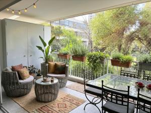 a patio with a glass table and chairs and plants at Las Condes familiar Deluxe in Santiago