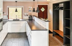a kitchen with white cabinets and black counter tops at 3 Bedroom Beautiful Home In Asperup in Asperup