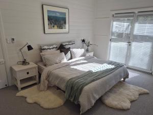 a bedroom with a bed and a table with a lamp at Finchy Cottage in Beechworth