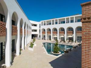 an exterior view of the courtyard of a hotel with a swimming pool at Mercure Conacul Cozieni in Bucharest