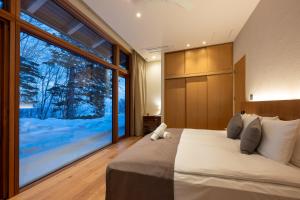a bedroom with a large bed with a large window at Kogetsu To 湖月燈 in Lake Toya