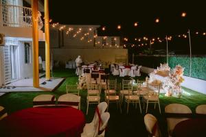a wedding reception with tables and chairs and lights at Anggun's palace in Pasir Gudang