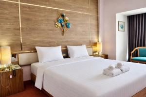 ein Hotelzimmer mit einem Bett, auf dem Handtücher liegen in der Unterkunft Asian Hotel in Hat Yai