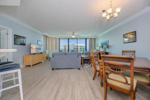 a living room with a table and a dining room at Phoenix on the Bay 1409 condo in Orange Beach